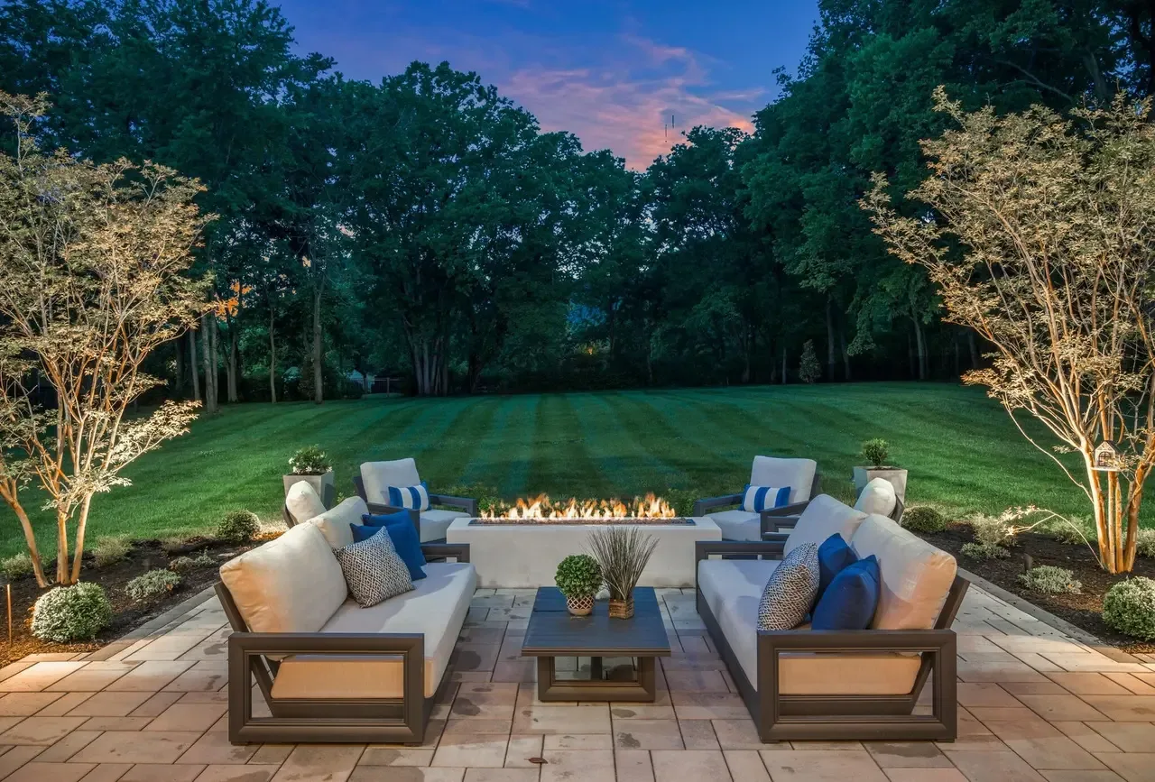 A patio with a fire bowl under an evening sky